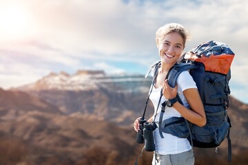 Happy young female with backpack on top mount