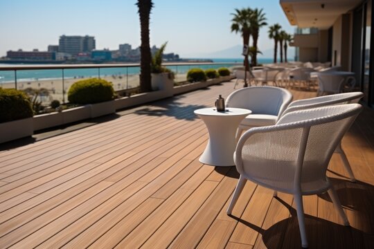 Chair and table on teak decking flooring outside a robby hotel.