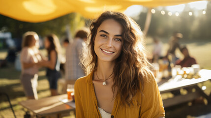 Portrait of young smiling woman during picnic party with her friends