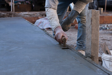 Close-up photo of a hand finishing a cement slab. Construction concept.