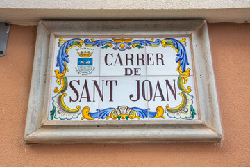 Street name written in calligraphy on a ceramic tile in Spain