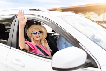Naklejka premium Cheerful beautiful elderly woman waving from car window