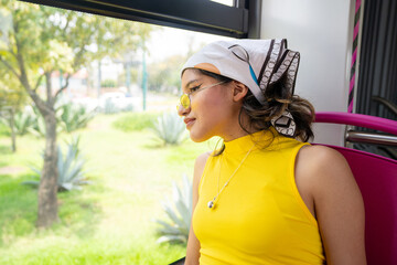 young mexican girl looks out the window sitting in the women-only area on the electric bus