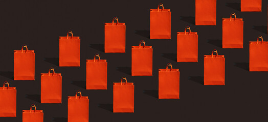 Black friday sale, shopping concept. Red paper shopping bag pattern on black background.