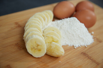 Fototapeta na wymiar close-up of ingredients for a cake, banana, eggs, flour on a board
