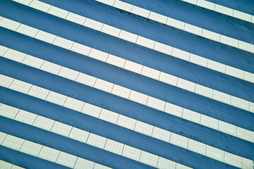 Aerial view of sustainable electrical power plant with solar photovoltaic panels covered with snow in winter for producing clean energy. Concept of low effectivity of renewable electricity in north