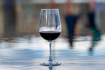 Tasting of Bordeaux blended red wine with wine city Bordeaux on background, left bank of Gironde Estuary, France. Glass of red French wine.