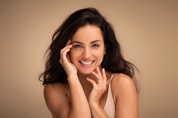Sensual beautiful young brunette woman touching her face