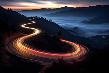 Stunning panoramic view of a winding illuminated mountain road at dusk, surrounded by natural beauty and greenery.