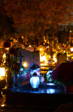 Cemetery at night with many burning candles. Catholic cemetery during All Saints' Day on November 1, celebrated in the Christian religion.