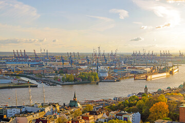 Beautiful view on the port of Hamburg during sunset with huge ships and cranes