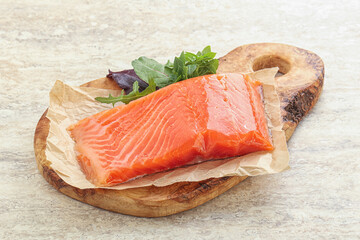 Raw salmon fillet over board