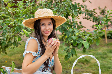 Beautiful young caucasian woman sitting in an orchard.