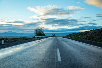 Naklejka premium empty asphalt road through the countryside of iceland at sunset
