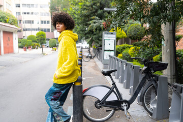 Man afro mexican looks direct at the camera at the bicycle parking station in Mexico City