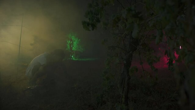 Scary Man With Chainsaw In Dark Night Misty Forest At moonlight