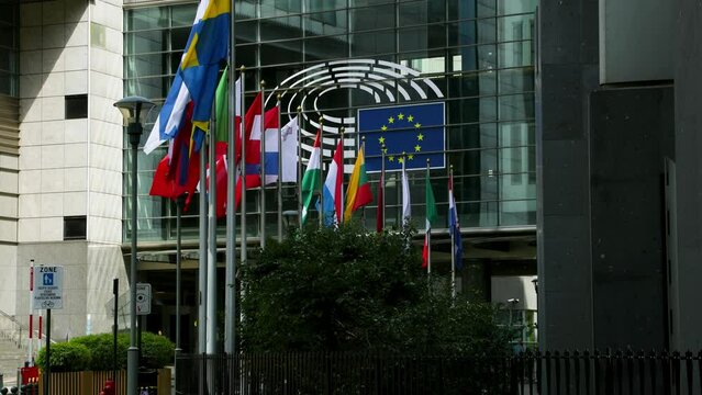 European Parliament headquarters. Peace Flags and states flags flying euro statues farmers protest tractors