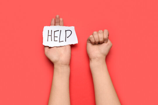 Woman With Clenched Fist And Word HELP On Red Background. Domestic Violence Concept