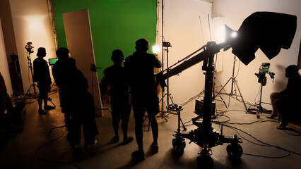 Silhouette images of making of or behind the scenes of video production which produced in the film studio that include all pro light and camera equipment and professional film crew with movie director - obrazy, fototapety, plakaty