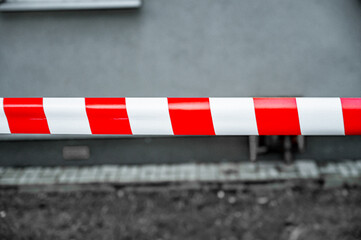Red and White Lines of barrier tape. at street background. Red White warning tape pole fencing is...