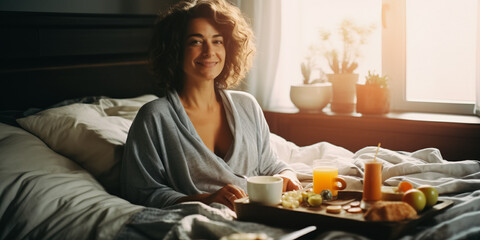 Beautiful mature woman with breakfast on bed