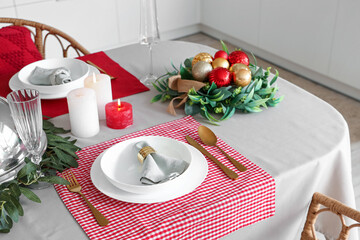 Christmas table setting with burning candles and wreathes