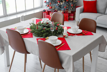 Christmas table setting with fir tree branches and burning candles