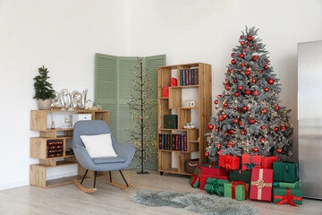 Interior of living room with Christmas tree, shelving units and armchair