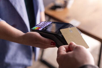 NFC credit card payment. Woman paying with contactless credit card with NFC technology. Wireless...