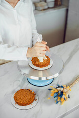 Confectionery, baking and cooking concept - woman making cake in the kitchen at home. The process of creating bento cake