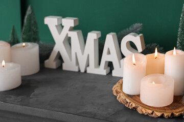 Christmas decor and burning candles on mantelpiece in festive living room, closeup