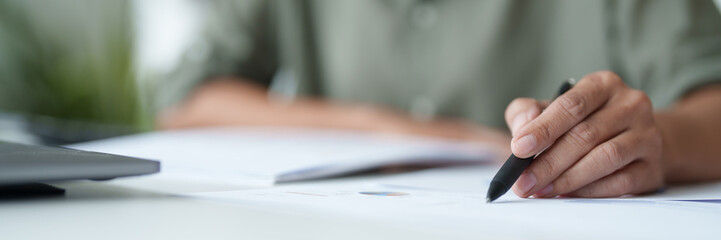 Businesswoman reading business document and working about calculating tax with laptop in office..