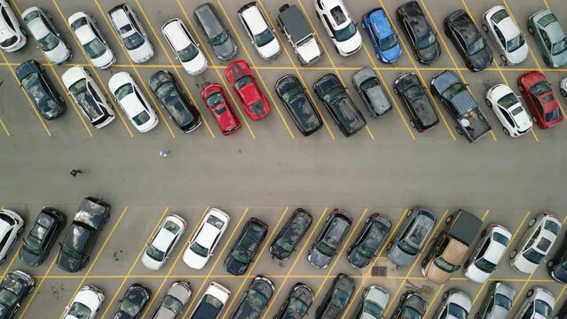 Aerial view from above flying drone car moving and standing on parking lot. Move camera