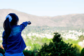 Girl pointing towards the mountains.