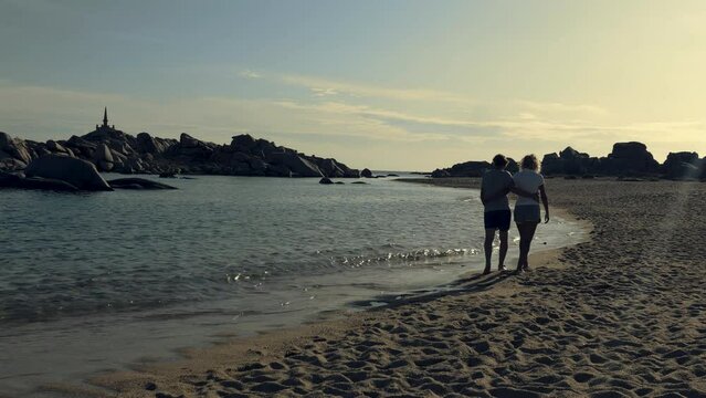 Couple strolls on the beach of Lavezzi island in Corsica, Mediterranean