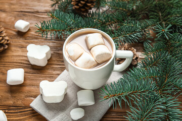 Obraz na płótnie Canvas Cup of tasty Christmas cocoa with marshmallows and fir branches on wooden background