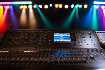 Live theater concert show sound video music control console with scene lights background. Sound engineer mixer soundboard equipment with many knobs, buttons, faders, equalizer screen and light - obrazy, fototapety, plakaty