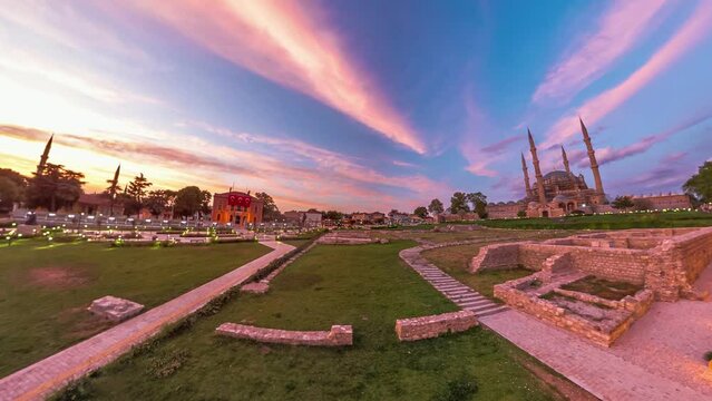 Edirne, Turkey evening with stunning cityscape. Eski Ulu Old Mosque and Selimiye Mosqueare in sunset golden hues, framed by graceful presence of Architect Sinan statue and Edirne Municipality building