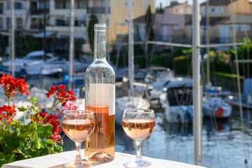 Pouring in glasses of cold rose Cote de Provence wine in yacht harbour of Port Grimaud, summer vacation on French Riviera Provence, France