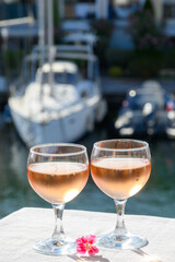 Pouring in glasses of cold rose Cote de Provence wine in yacht harbour of Port Grimaud, summer vacation on French Riviera Provence, France