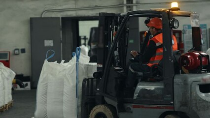 Material handling, Equipment operation, Loading dock. Pallet movement in warehouse is ensured by forklift loader operated by skilled worker.
