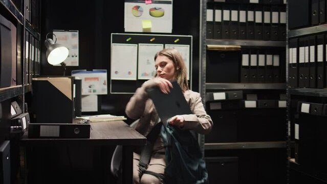 Solving the crime, private detective comes and examines evidence on personal computer. Female police officer with backpack enters workplace and sets laptop on desk to check records and analyse clues.