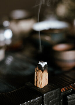A lighted Palo Santo stick on a tea board (chaban).