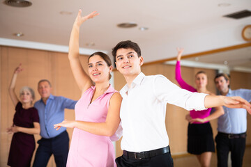 Young happy couple performing a paired dance in ballroom