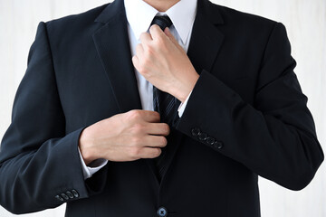 ネクタイを整えるビジネスマン
