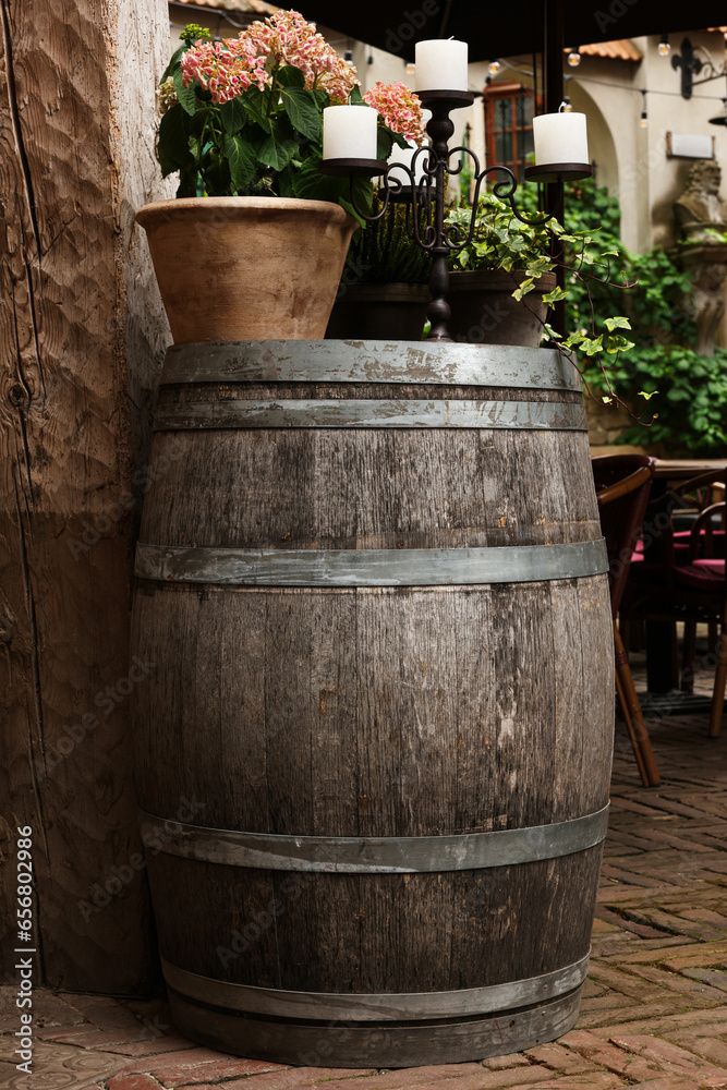 Wall mural Traditional wooden barrel, beautiful houseplant and candlestick outdoors