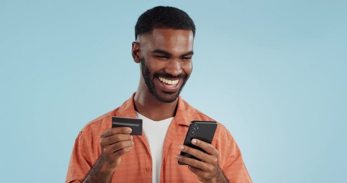 Man, credit card and excited with phone, studio and thinking of sale, promo code or info by blue background. Online shopping, easy payment and happy for financial freedom, fintech app or smartphone