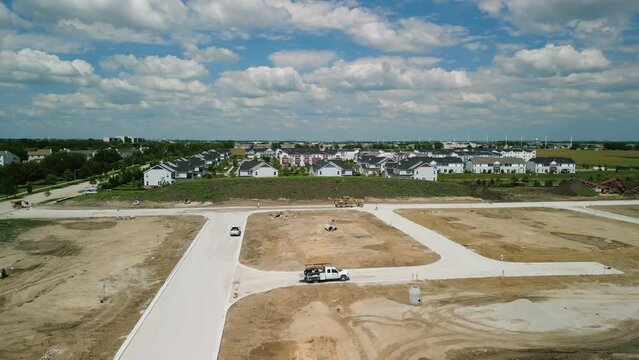 Aerial of suburb in pre construction empty lots and home