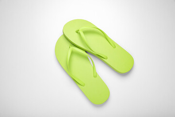 Light green flip flops on white background, top view
