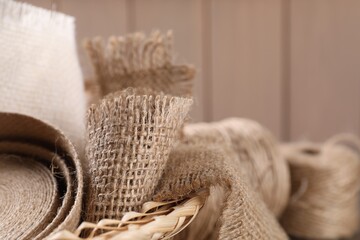 Obraz na płótnie Canvas Pieces of burlap fabric in wicker basket, closeup